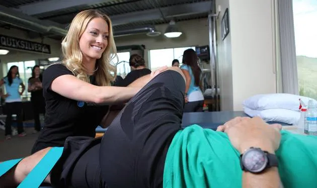 Physical therapist assisting a client with Fascial Stretch Therapy in a rehabilitation setting, promoting flexibility and recovery.